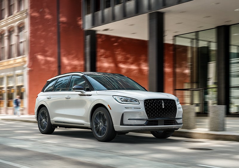 The 2024 Lincoln Corsair® SUV with the Jet Appearance Package and a Pristine White exterior is parked on a city street. | Parks Lincoln of Tampa in Tampa FL